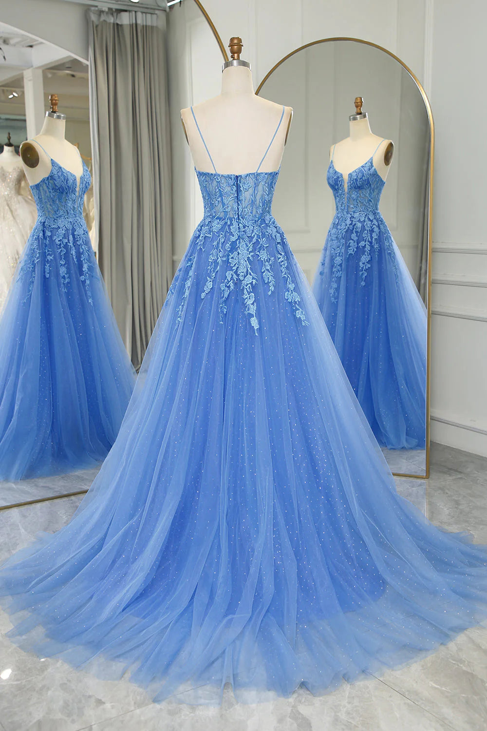 Side view of a blue A-line tulle prom dress with intricate appliques.