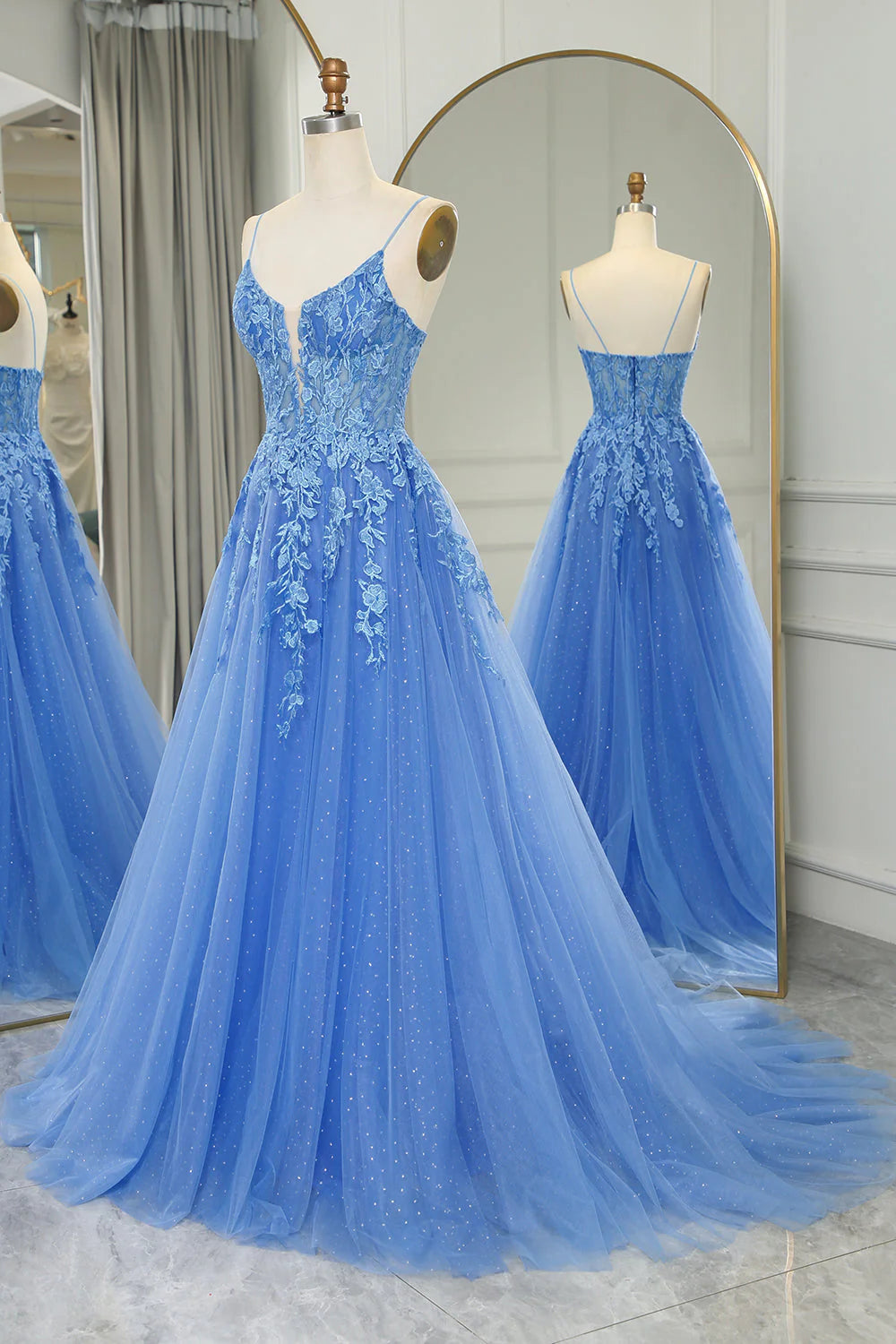 Close-up of delicate appliques on the blue tulle fabric of the prom dress.