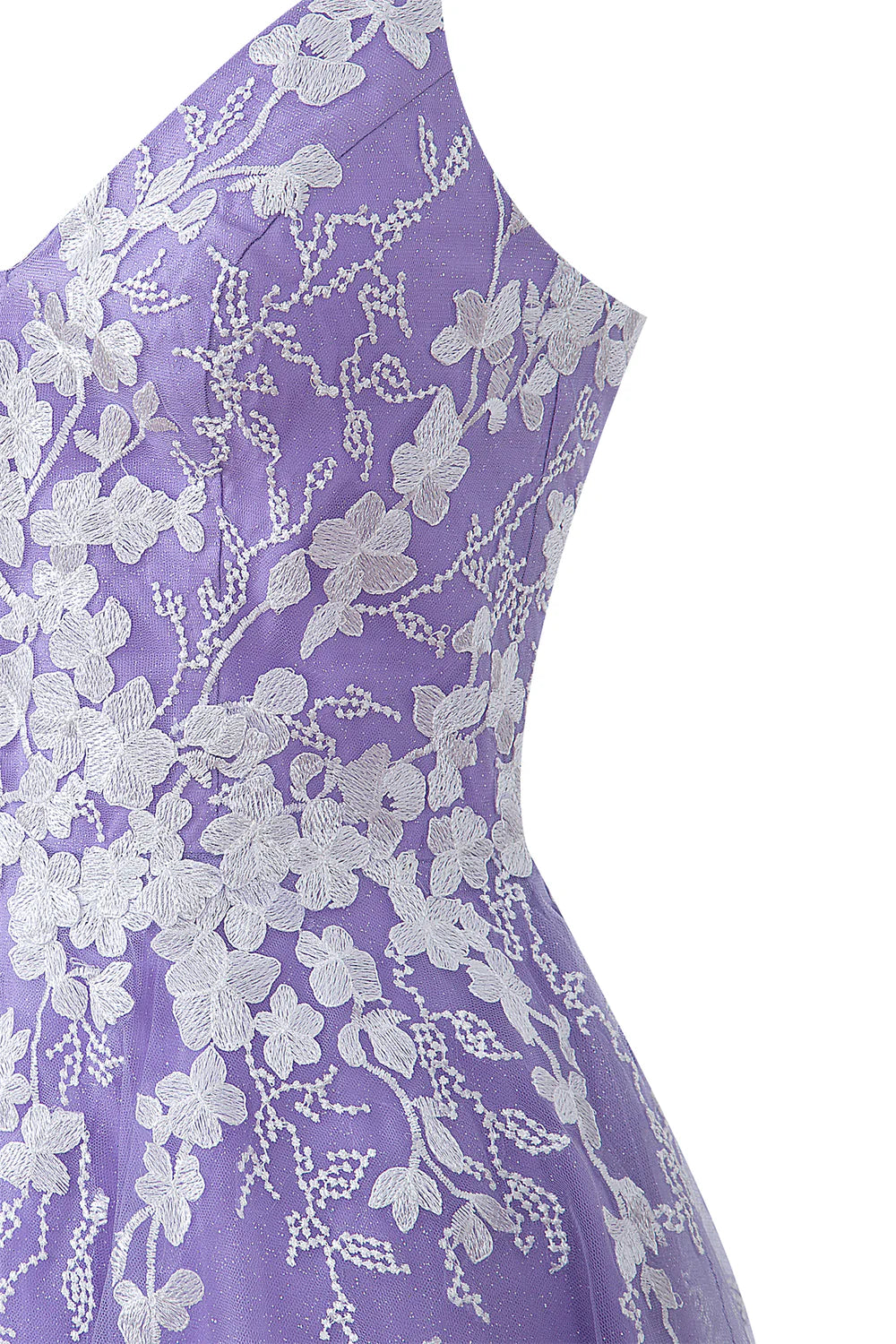 Close-up of the intricate appliques on the tulle fabric of the dress.