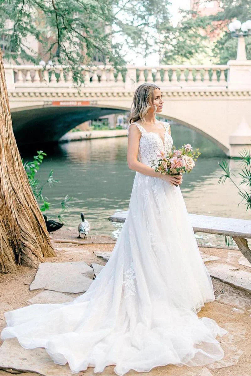 Bride in A-line V-neck wedding dress with tulle appliques.