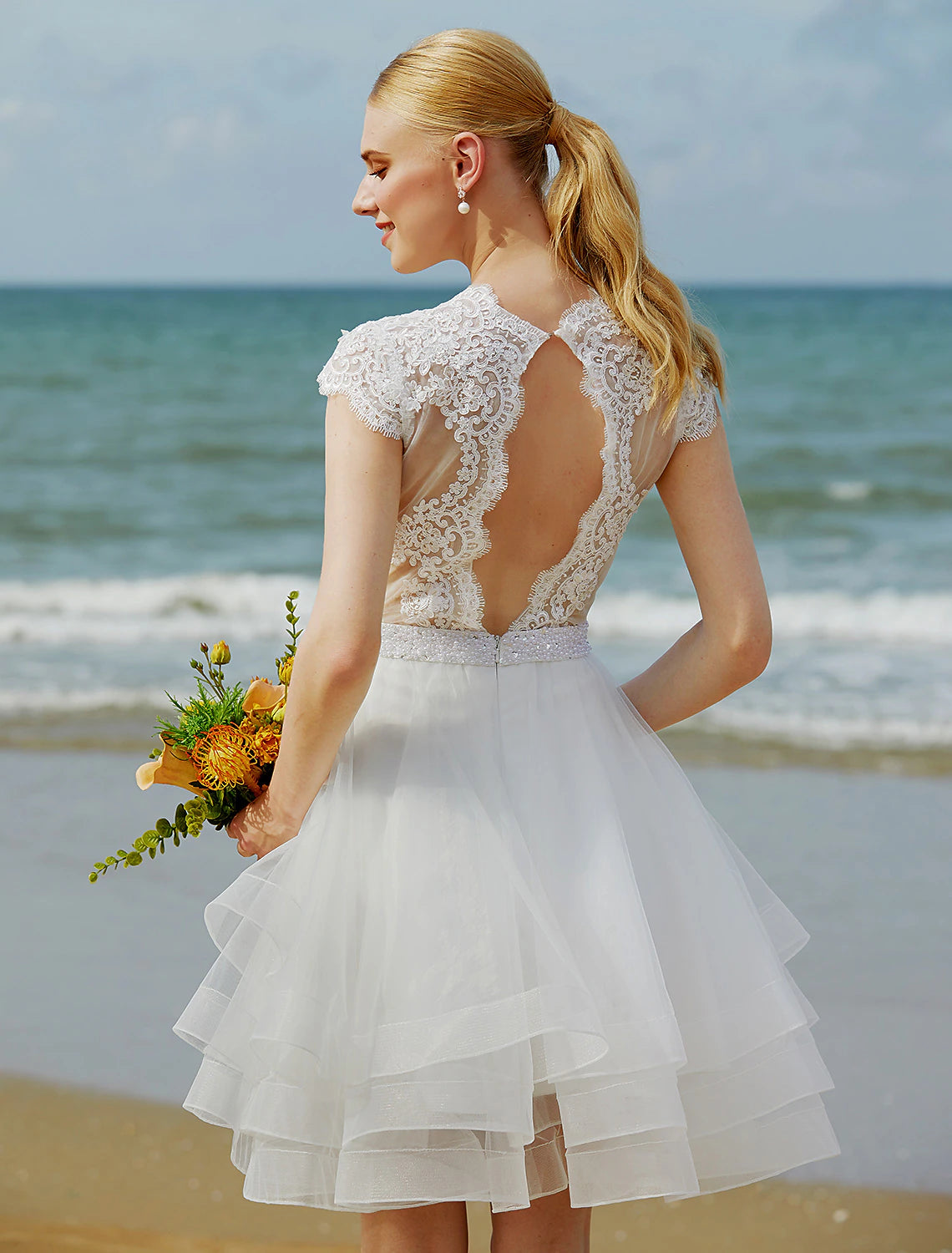 Side view of the knee-length bridal gown with sash.