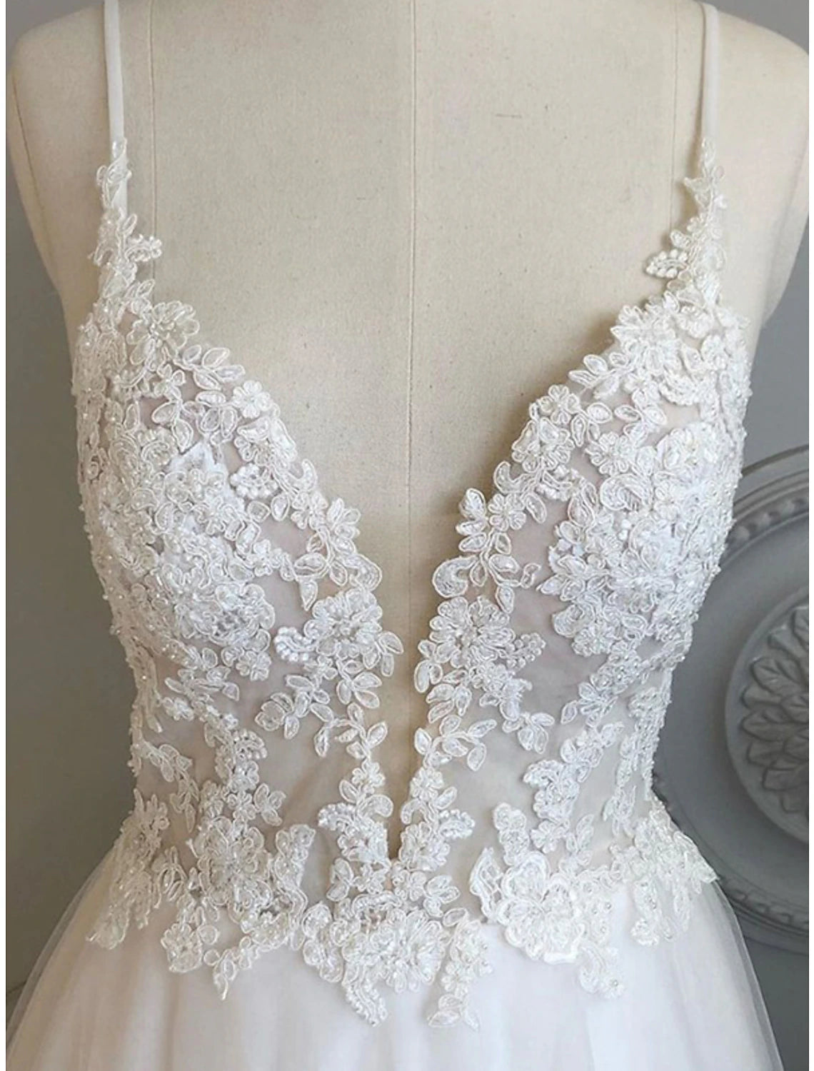 Close-up of beading appliques and shoulder flower on tulle gown.