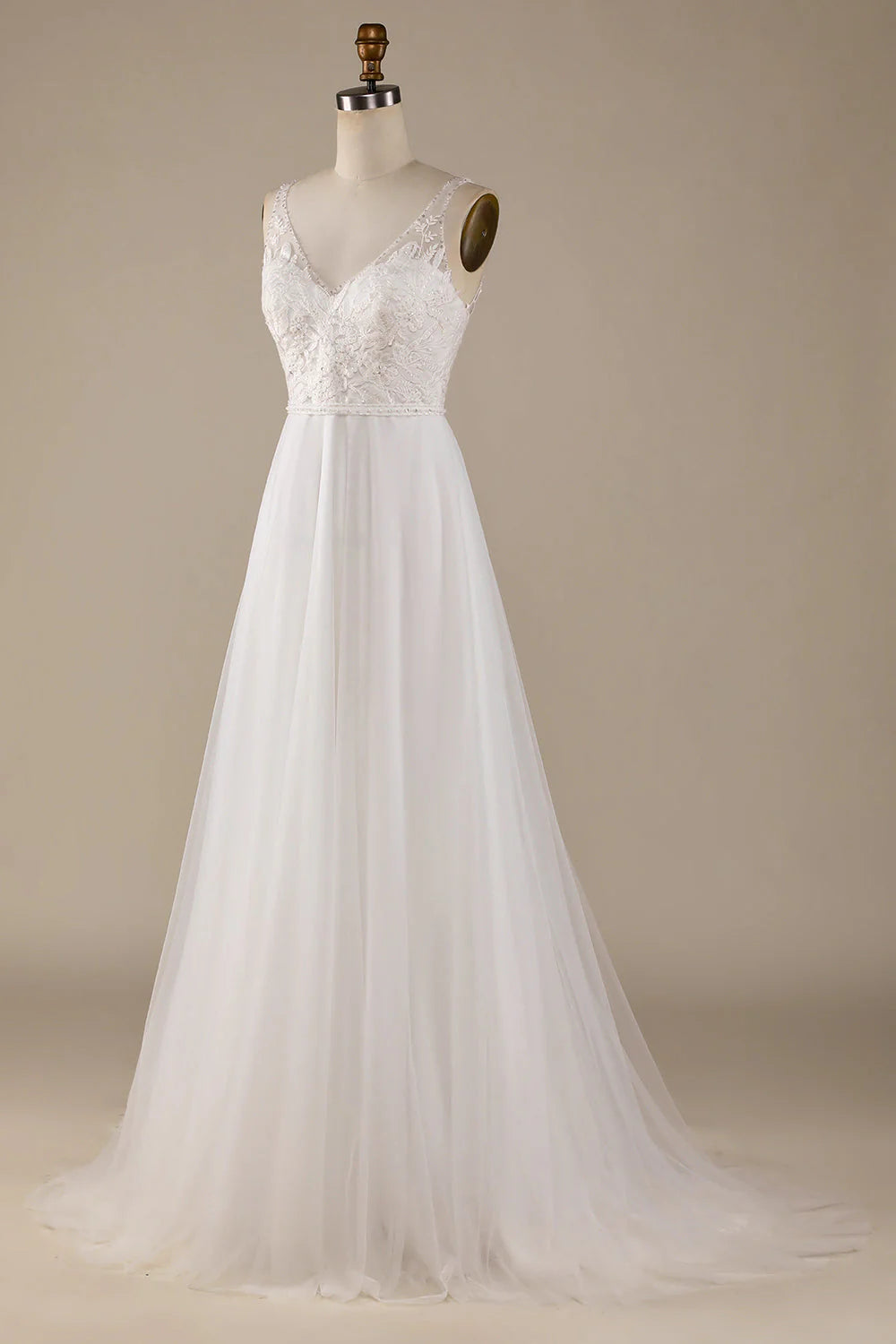 Side view of a bride in an ivory V-neck tulle wedding gown with intricate lace embellishments.