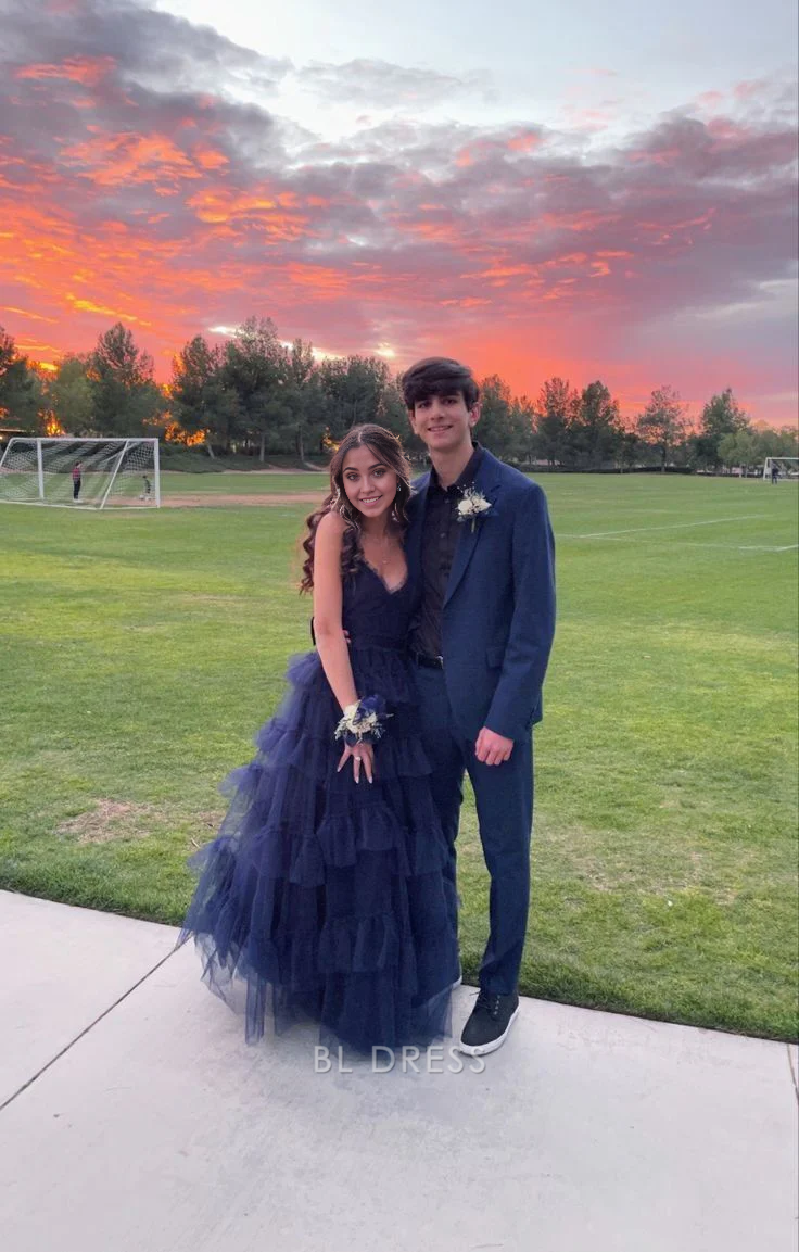Woman wearing a navy blue A-line V-neck tulle formal dress.