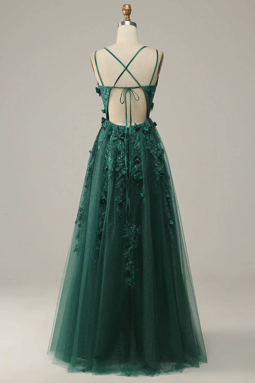 Side view of a dark green A-line tulle gown, showcasing the flowing skirt and slit.