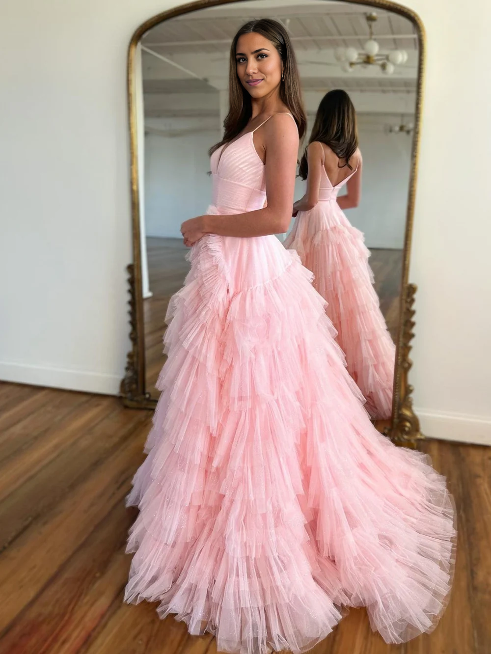 Model posing in a flowing A-line tulle prom dress.