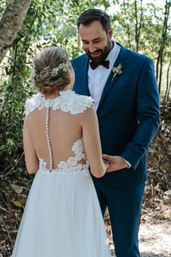 Back view of A-Line white wedding gown featuring appliques and sweep train.