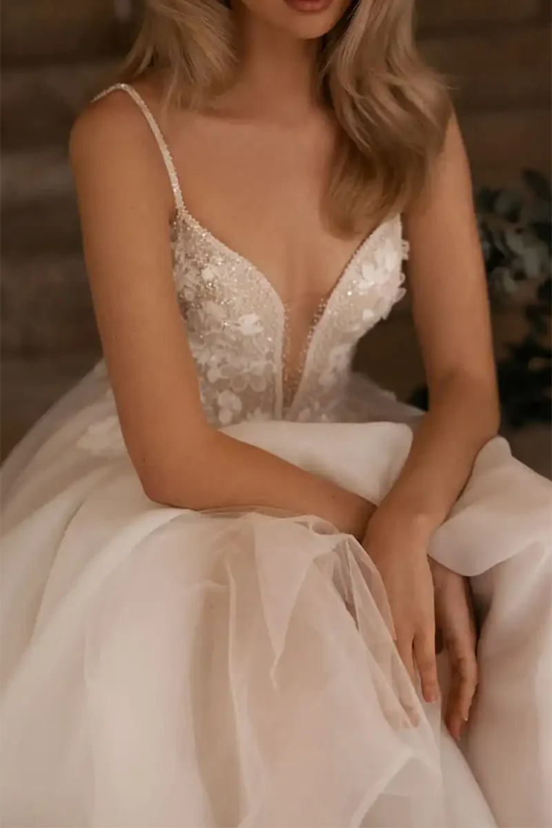 Full view of a bride wearing the sleeveless A-line V-neck wedding dress.