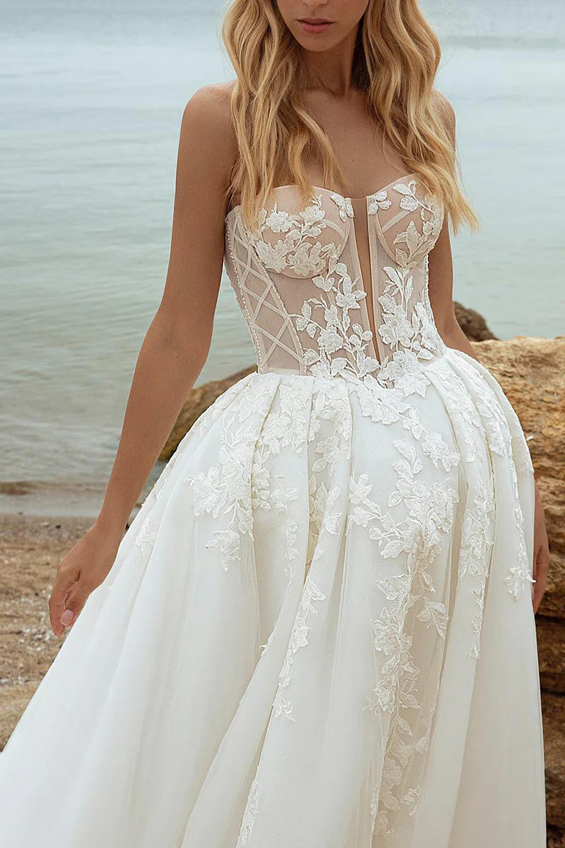 Close-up of lace appliques on the long sleeve of an A-line wedding dress.