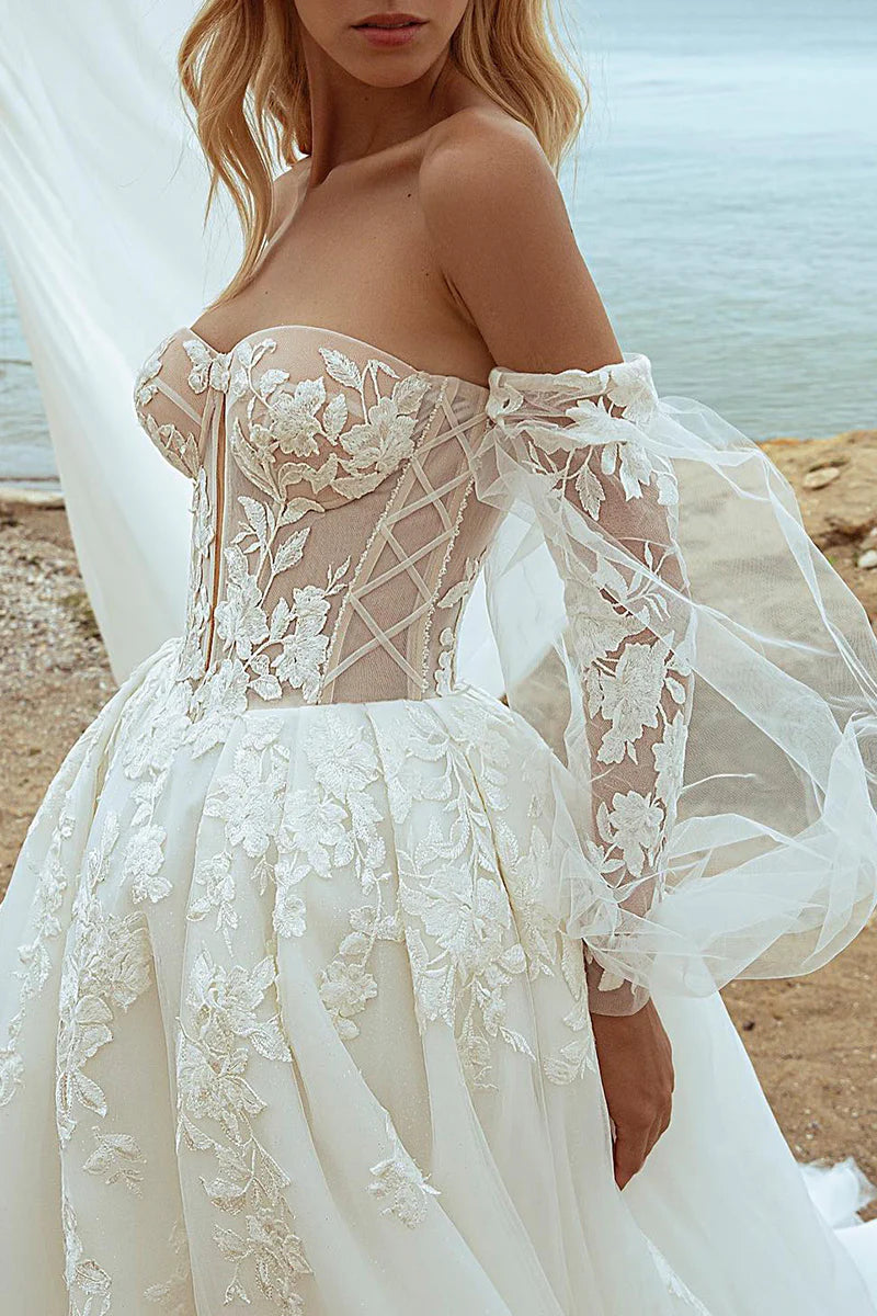 Back view of an A-line V-neck wedding dress with long lace sleeves.
