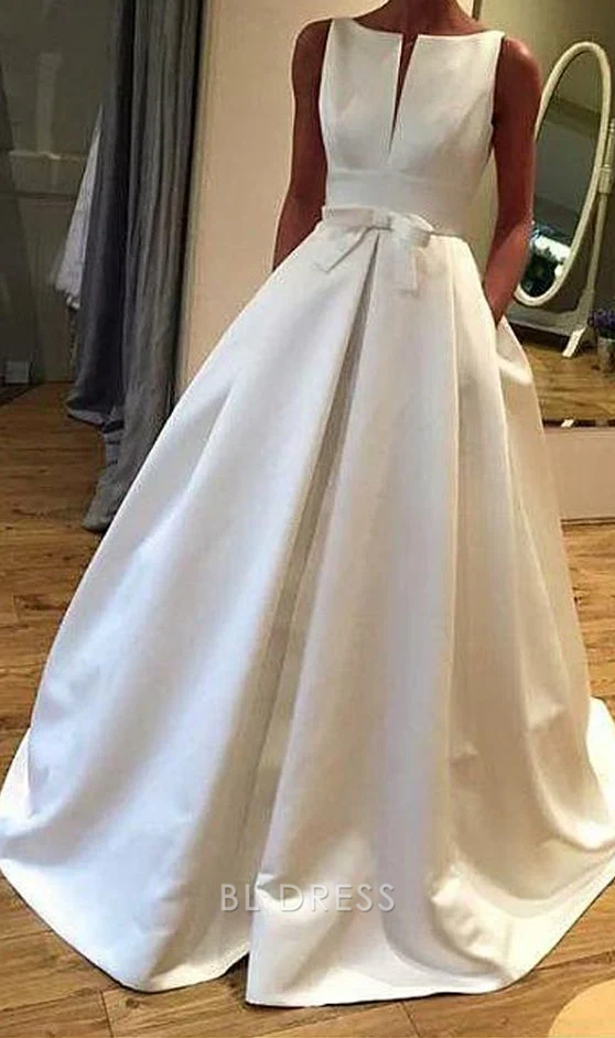Full-length view of a woman wearing an elegant white satin A-line V-neck gown.