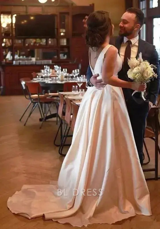 Close-up of the white satin A-line V-neck gown, showing fabric detail and neckline.