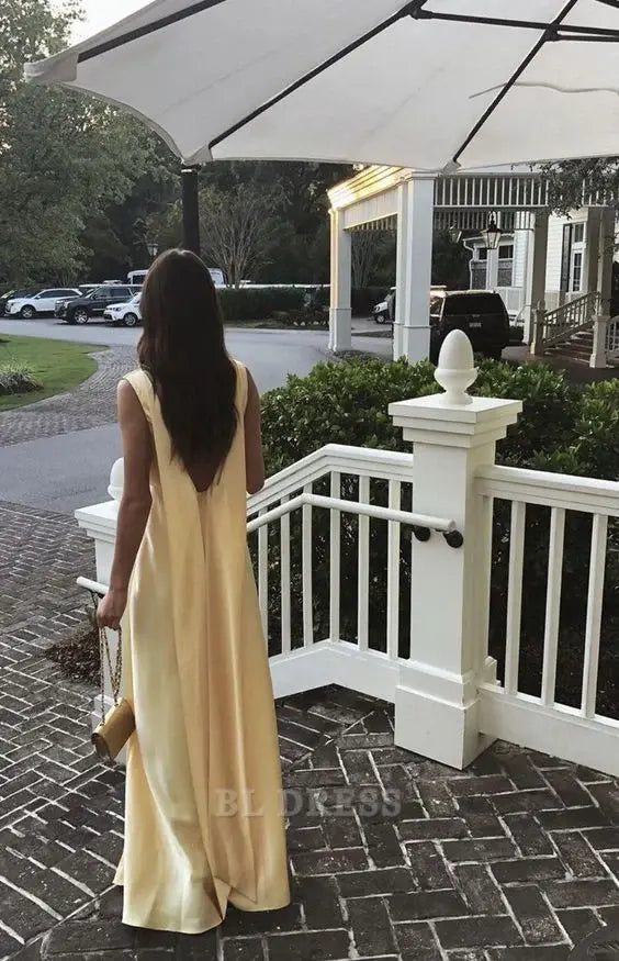 Full length view of a yellow satin A-line V-neck formal gown.