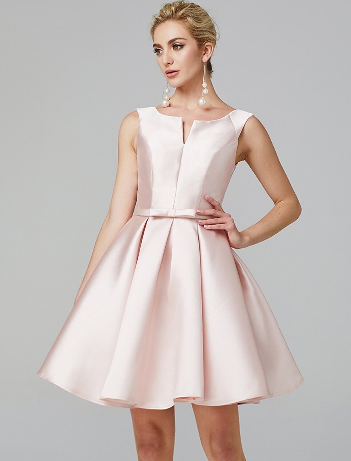 Back view of the pleated satin dress, showing the delicate bow detail.