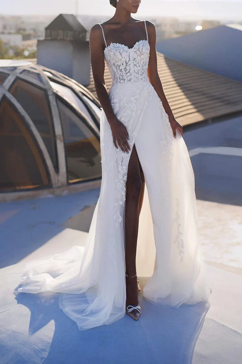 Front view of an A-line wedding dress with spaghetti straps and lace appliques.