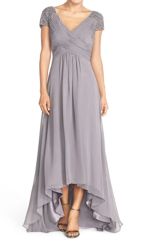 A woman wearing an elegant A-line chiffon dress with an asymmetrical neckline.