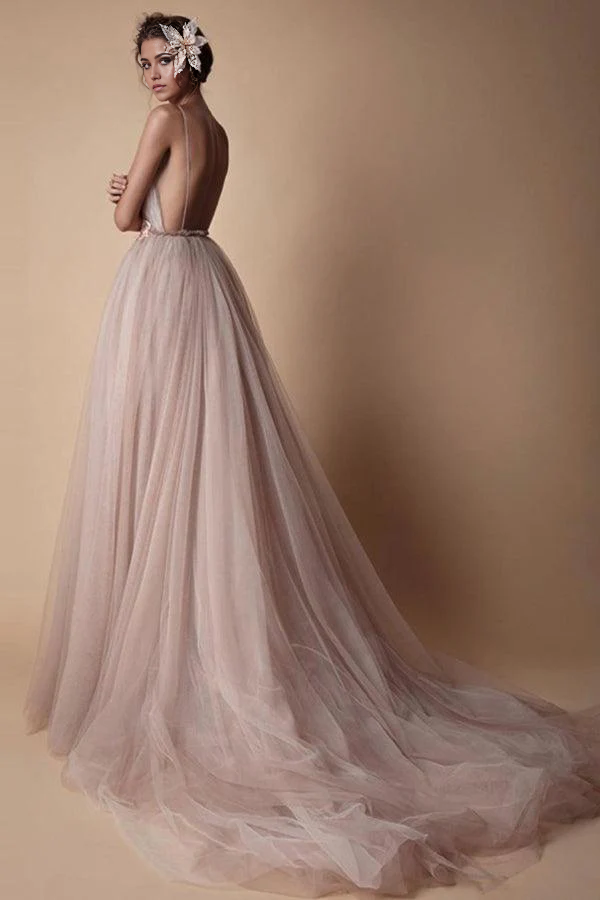 Close-up of the bodice of an A-line wedding dress, showing deep V-neck, spaghetti straps, and applique details.