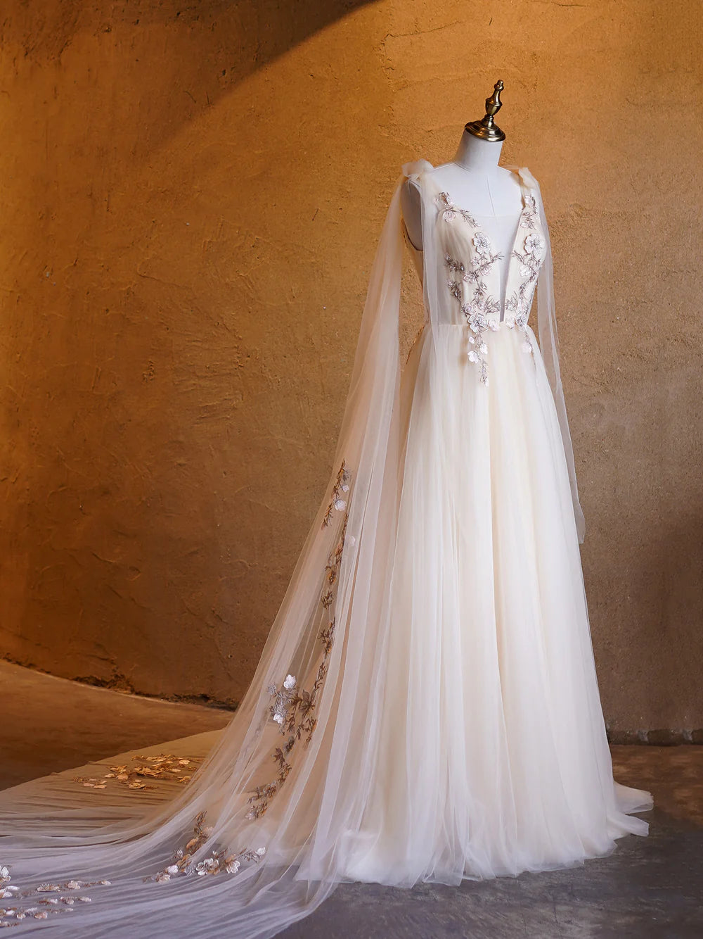 Close-up of the deep V-neckline and delicate tulle fabric.