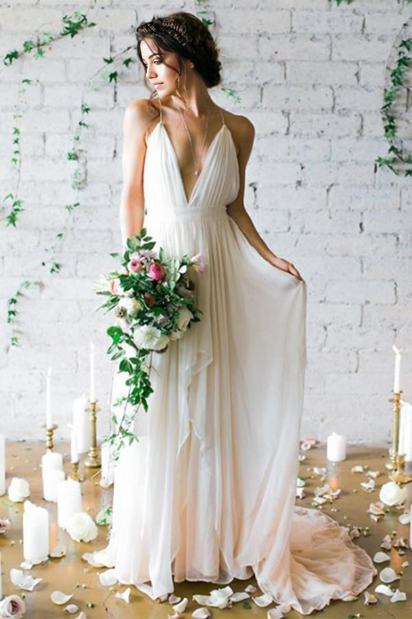 Elegant A-line ivory wedding dress with deep V-neck, delicate straps, and a sweep train, viewed from the front.