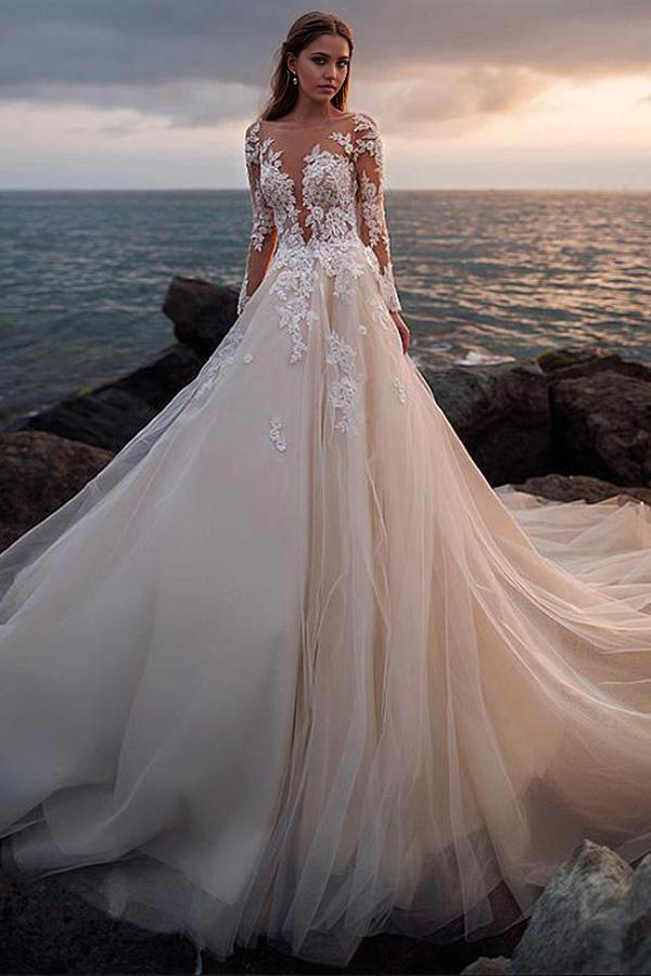 Front view of an elegant ivory A-line tulle wedding dress with illusion lace long sleeves and a V-neck.