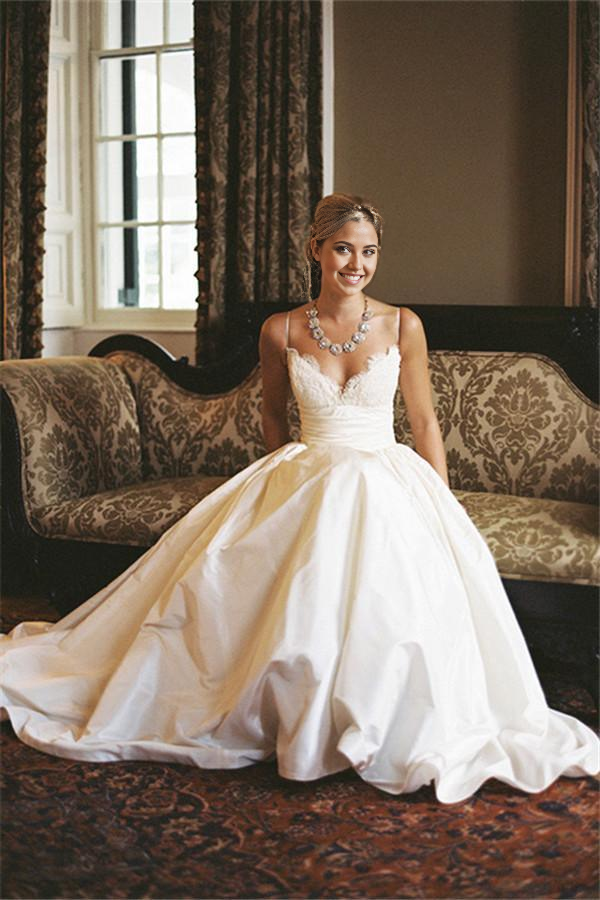 Elegant A-line lace wedding dress with V-neck and spaghetti straps.