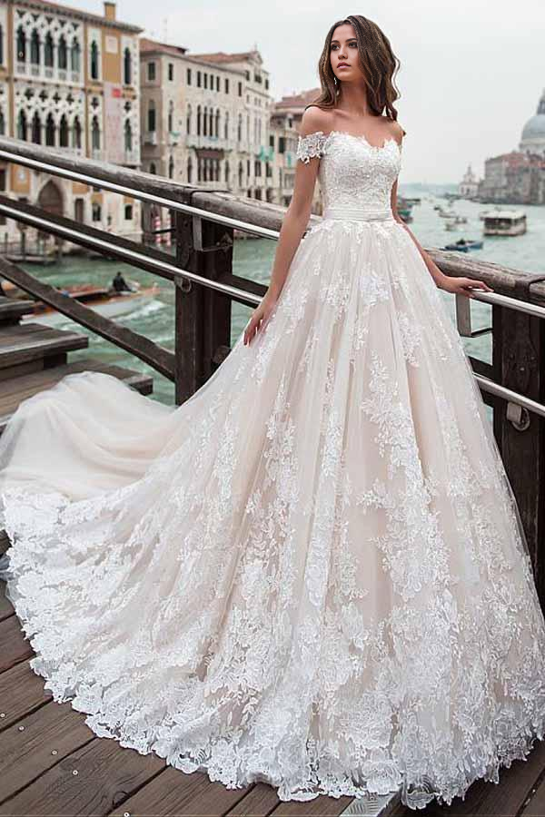 Full view of an elegant A-line off-shoulder wedding dress with delicate appliques and lace.