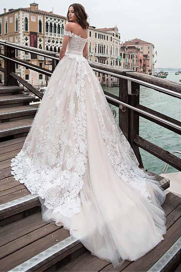 Close-up of the off-shoulder neckline and intricate applique details on the wedding dress.