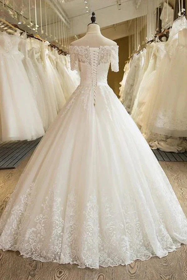 Close-up of lace details on an A-line off-shoulder wedding dress.