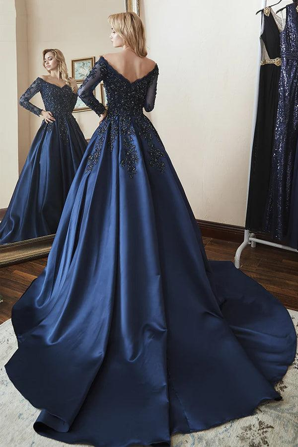 Side view of the navy blue A-line off-shoulder long sleeve beaded prom gown.
