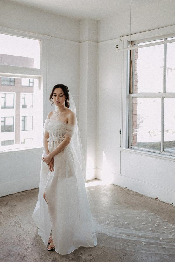 Close-up of the delicate lace and thigh-high slit on the satin wedding gown.