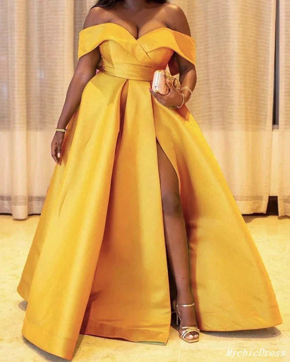 Back view of a woman in a flowing A-line satin evening gown.