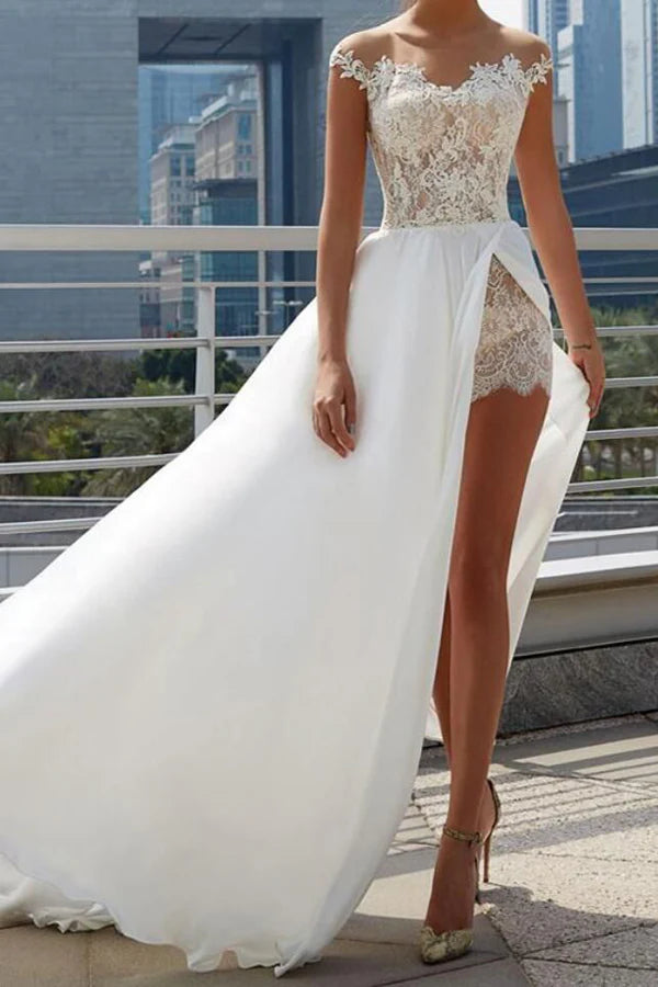 Model wearing an elegant A-line off-shoulder white wedding dress with sheer lace details and a side slit.