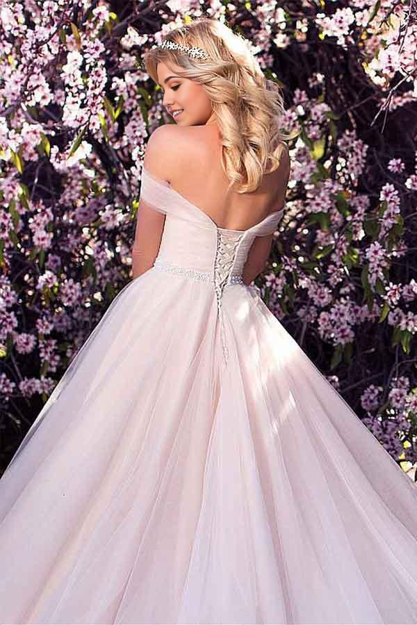 Full view of an A-line bridal gown featuring an off-shoulder design and flowing skirt.