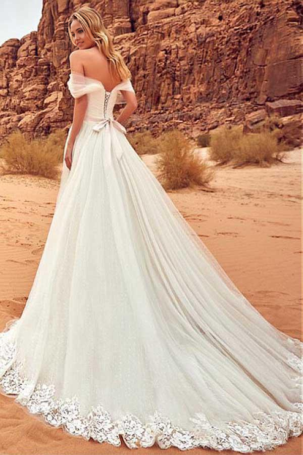 Close-up of lace appliques on the off-shoulder neckline of a wedding gown.