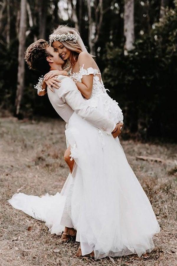 Back view of the white A-line off-shoulder wedding dress showing applique details.