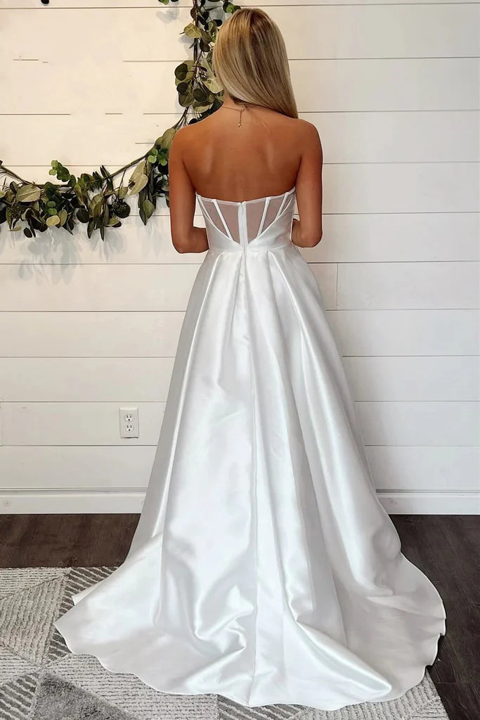 Model showcasing a white off-the-shoulder A-line bridal gown with a front slit.