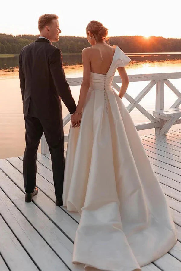 Bride wearing a vintage one-shoulder A-line wedding gown.