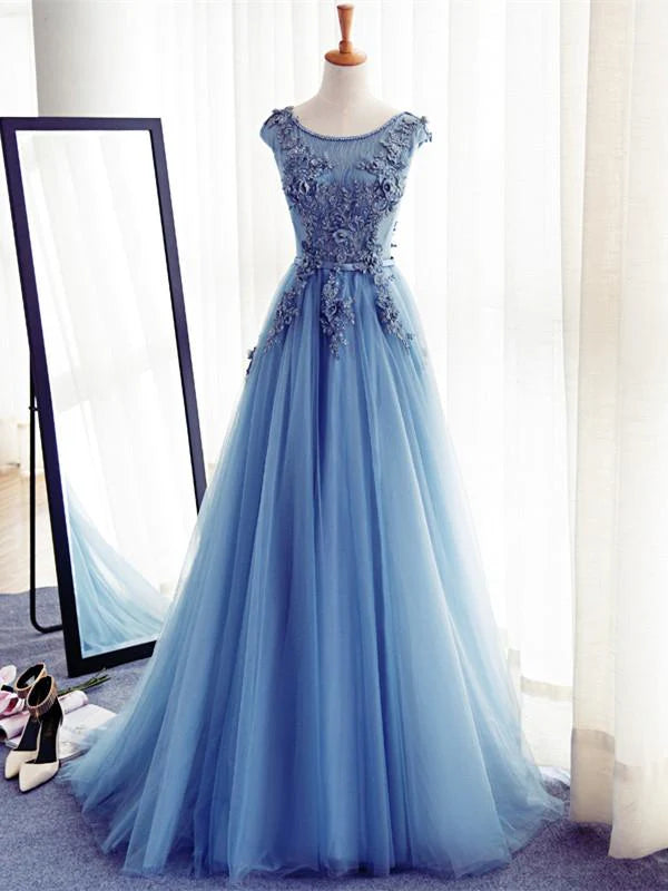 Woman wearing a navy A-line lace prom dress with a round neck.