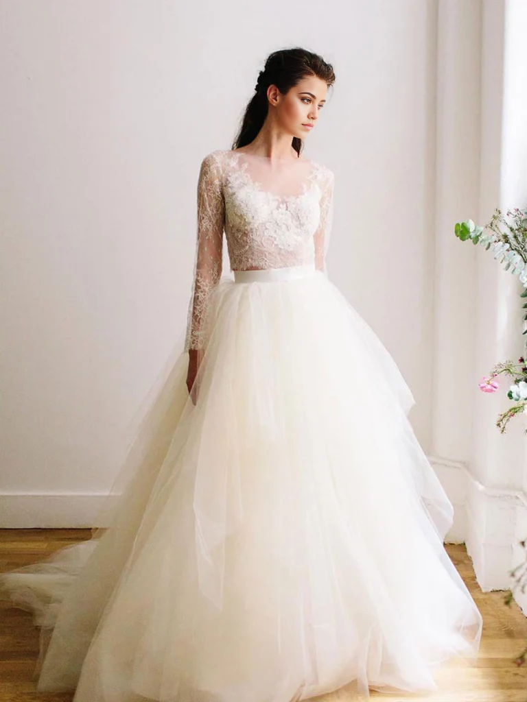 White A-line wedding dress with long sleeves and round neck, featuring lace and tulle fabric.