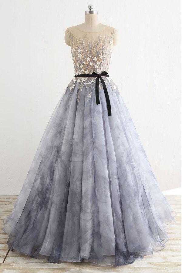 Woman wearing an elegant A-line round neck long sleeve tulle prom dress.