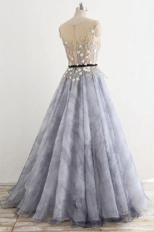 Woman posing in a flowing A-line long sleeve tulle formal dress.
