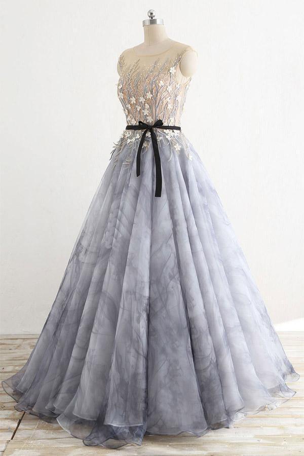 Side view of a woman in a round neck A-line tulle prom gown.