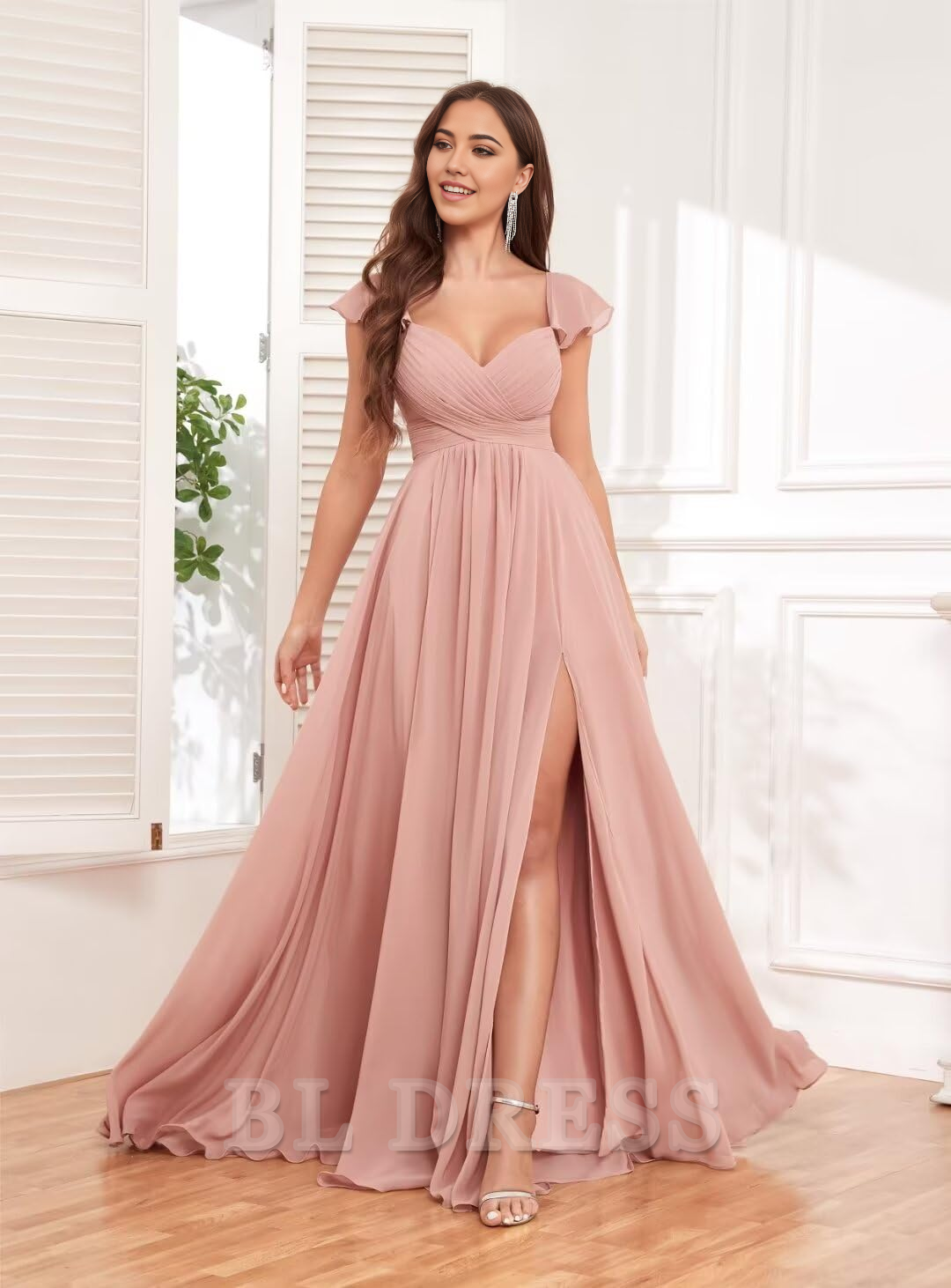 Model wearing a backless pleated bridesmaid dress with a flowing skirt.