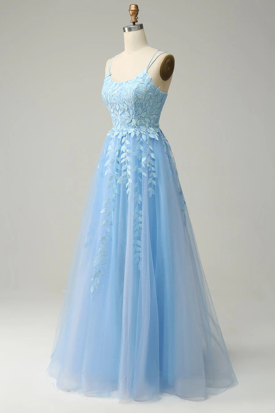 Side profile of an embroidered A-line prom gown with a scoop neck.