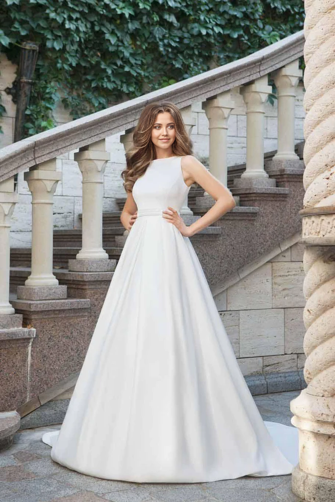 Back view of a bride wearing an A-line satin gown with a flowing train.