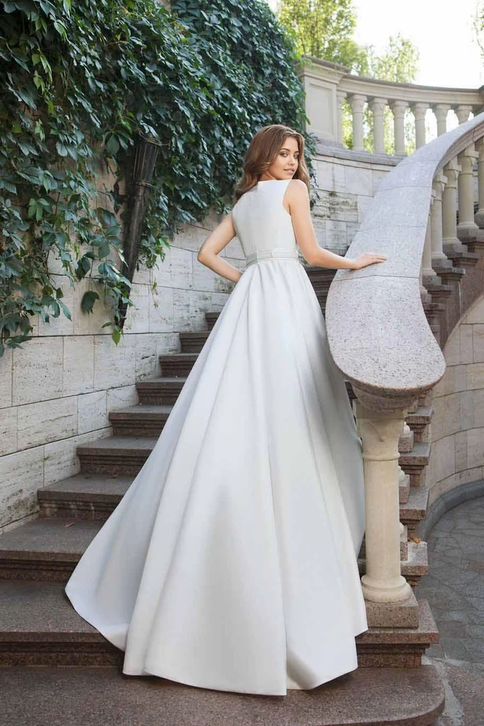 Side profile of an A-line scoop neck bridal gown in satin.