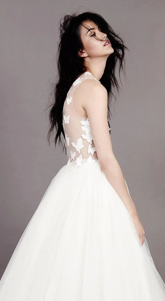 Close-up of delicate butterfly appliques on the tulle fabric of an A-line wedding dress.