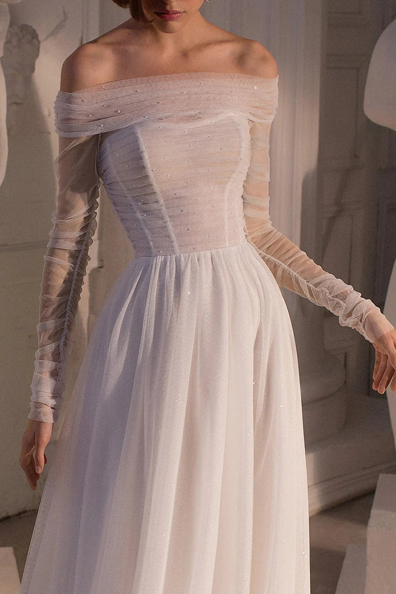 Side profile of a bride wearing an A-line strapless wedding dress with a flowing sweep train.