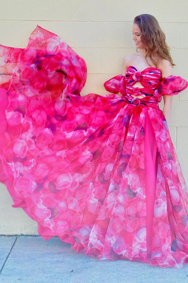 Side view of a model in a floral A-line prom dress, showing the long skirt.