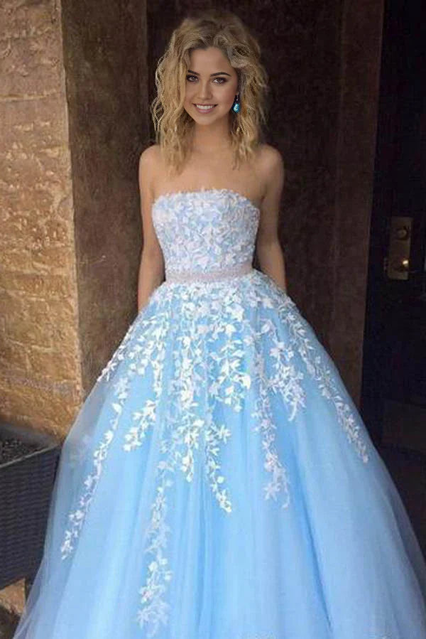 Woman wearing an elegant A-line strapless long prom dress with lace appliques and flowing tulle.